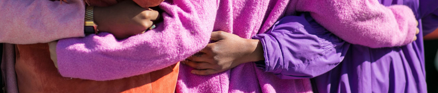 International Women\'s Day speakers page header - women hold hands together behind their backs - photo creative commons Vonecia Carswell 